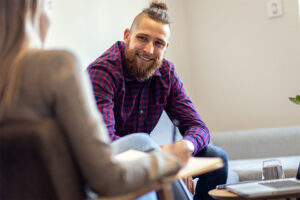 man smiling in therapy for addiction aftercare