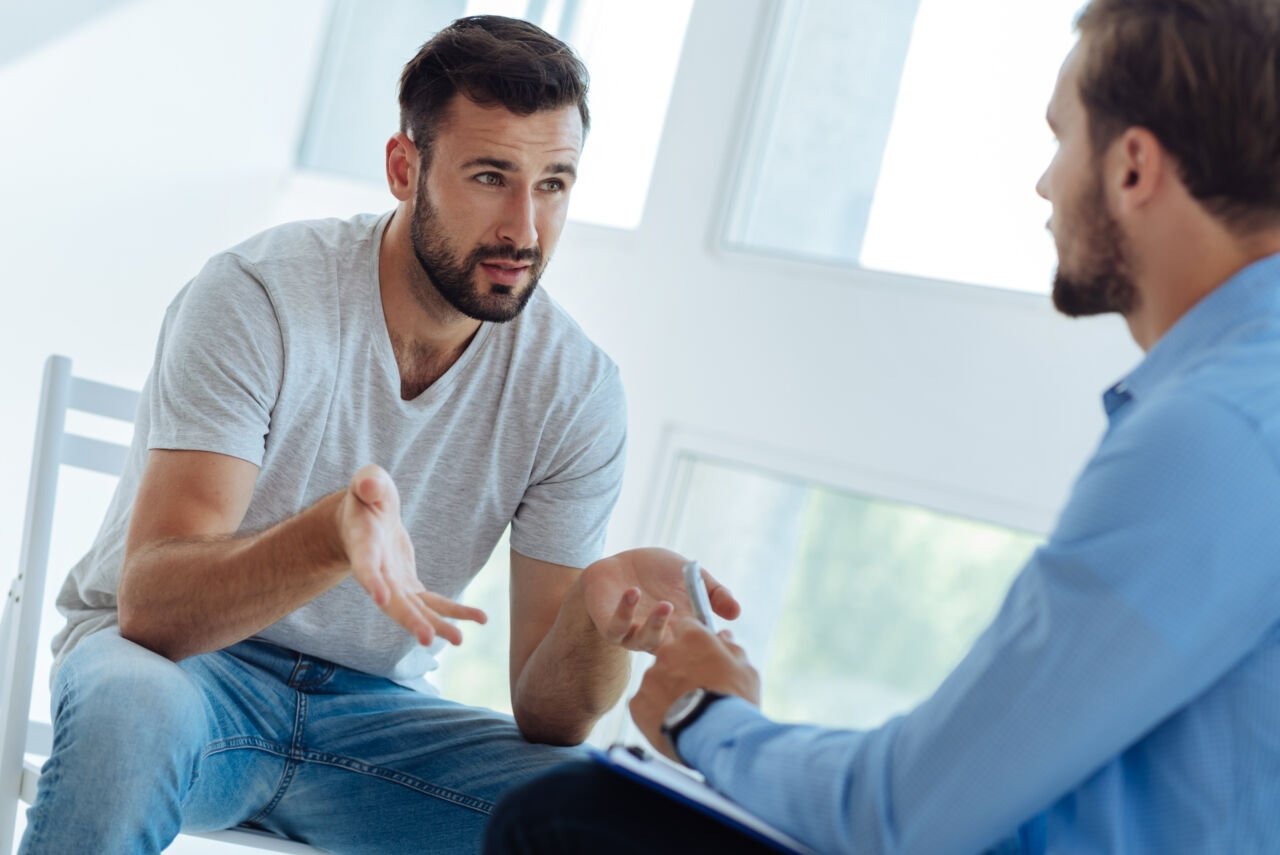 a man with alcohol addiction speaking to a therapist about effects of alcohol on blood